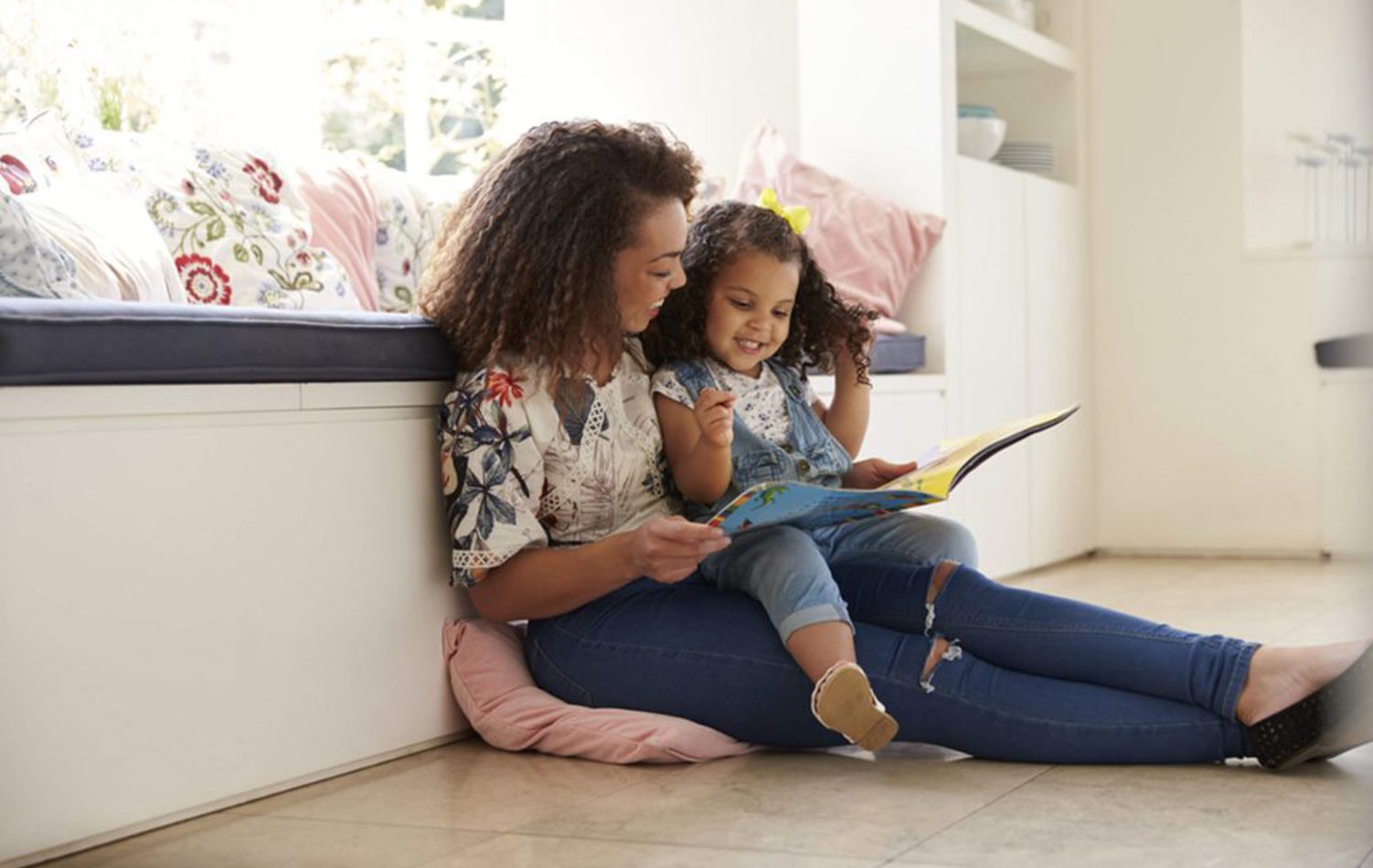 A mother and her daughter sat together reading a book