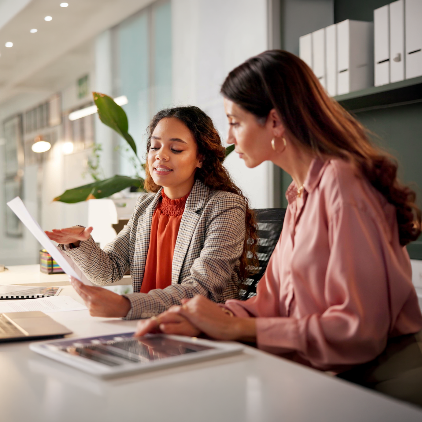 A female adviser sat at a desk having a conversation with a client on the computer