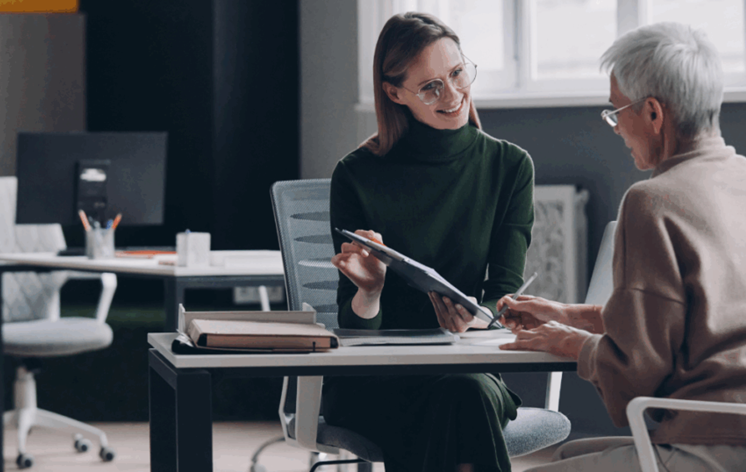 A woman sat at a desk having a meeting with a female adviser
