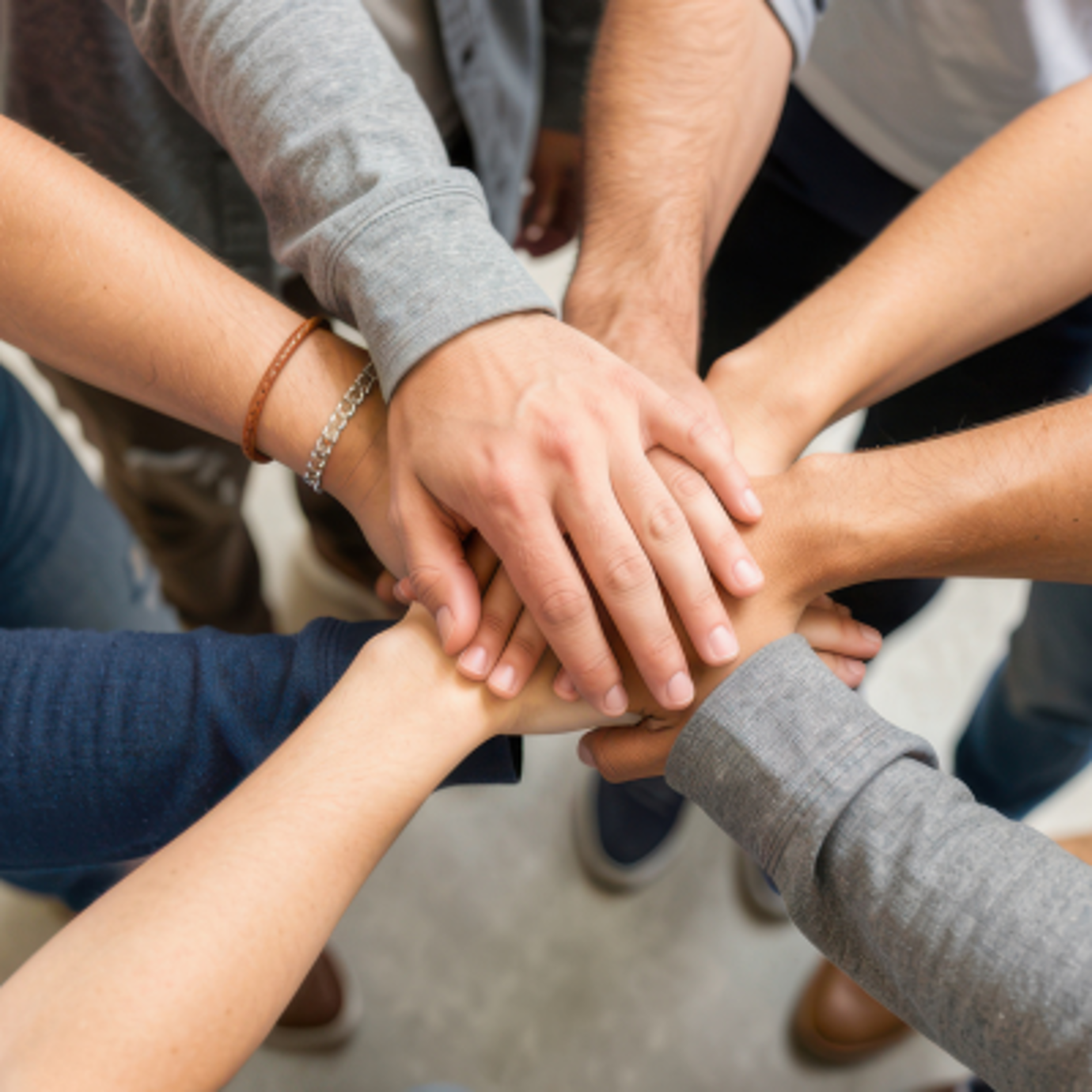 A circle of people holding their hands together in the middle